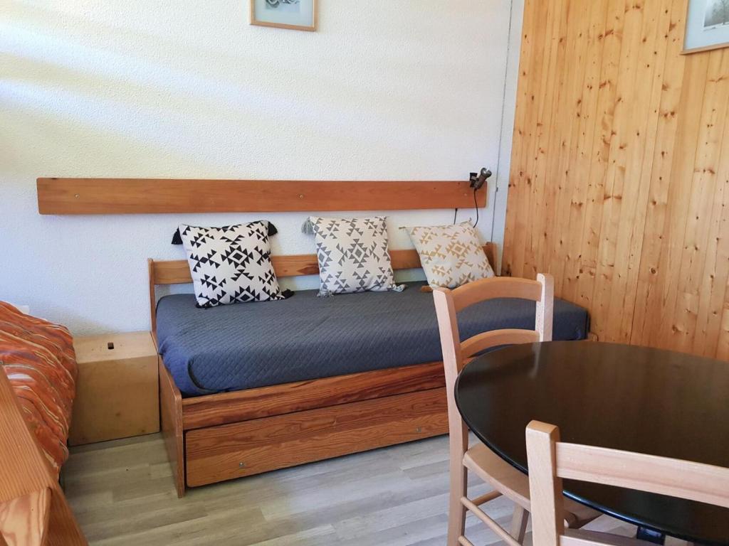 a small bedroom with a bed and a table at Résidence Cascade - Studio pour 2 Personnes 56 in Arc 1600