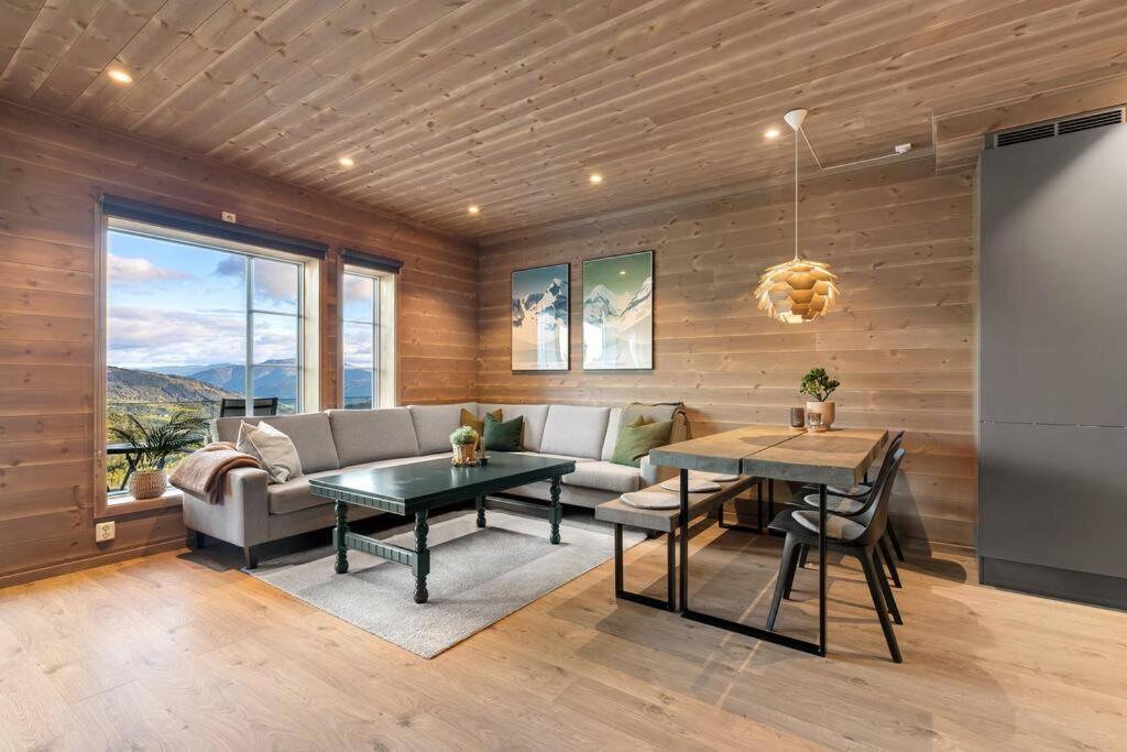 uma sala de estar com um sofá e uma mesa em Leilighet - Panorama view - Sogndal Skisenter Hodlekve em Sogndal