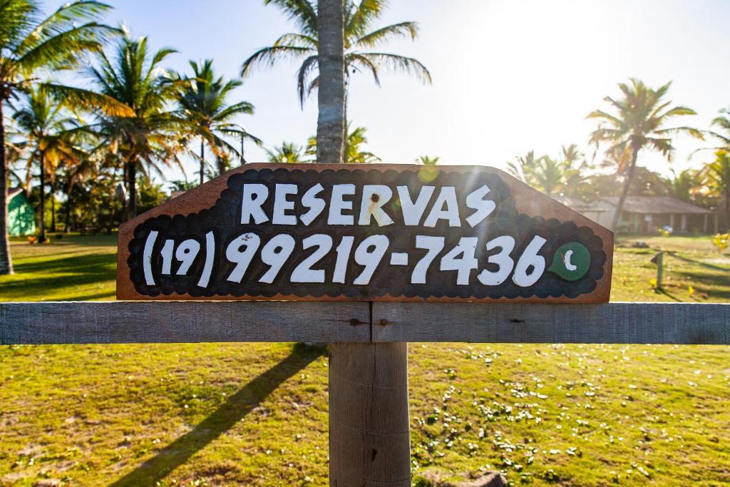 um sinal para um resort num parque com palmeiras em Pousada Vila Rosa - Caraiva em Caraíva