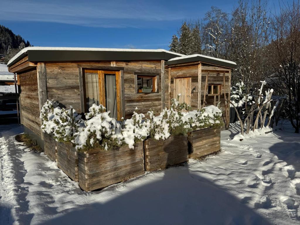 una casa exterior de madera con nieve en el suelo en Chalet at Ski Lift (Gsteig b. Gstaad), en Gsteig