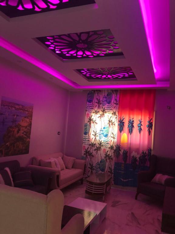 uma sala de estar com iluminação roxa e sofás em New Villa Carimo em El Quseir