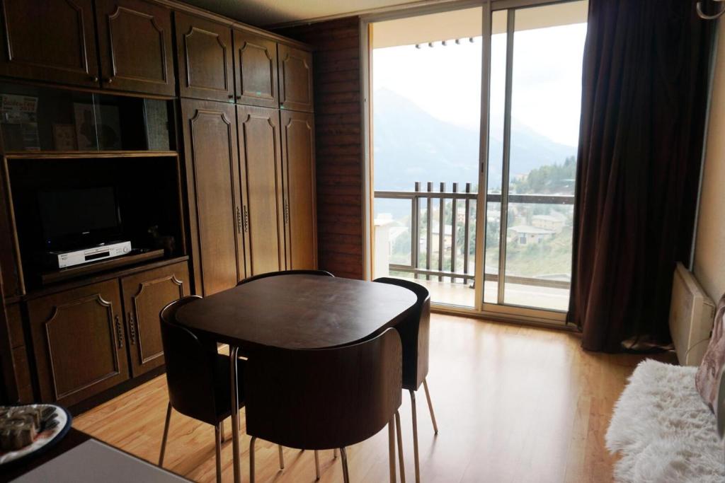 une salle à manger avec une table et des chaises et un balcon dans l'établissement Résidence Vallonpierre B - Studio cabine 4 personnes MAE-2819, à Orcières