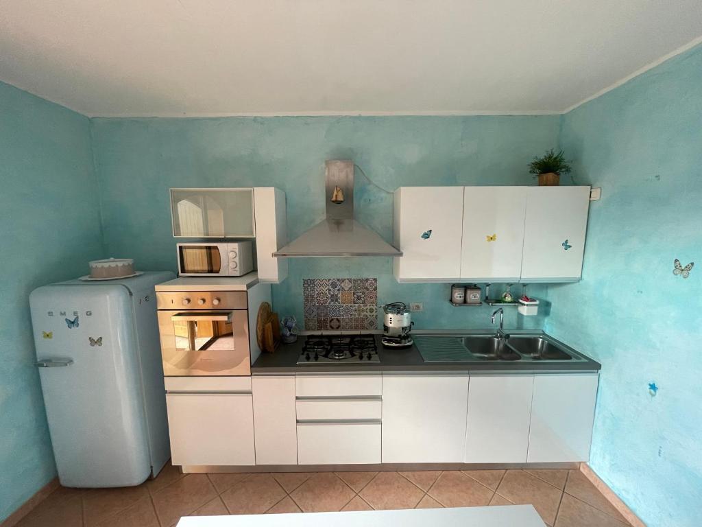 芡歐的住宿－Casa delle Farfalle，厨房配有冰箱和炉灶。 顶部烤箱