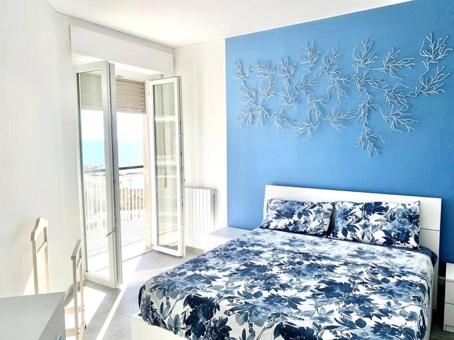 um quarto azul com uma cama e uma parede azul em [10 min. da Sanremo] Appartamento Vista Mare em Taggia