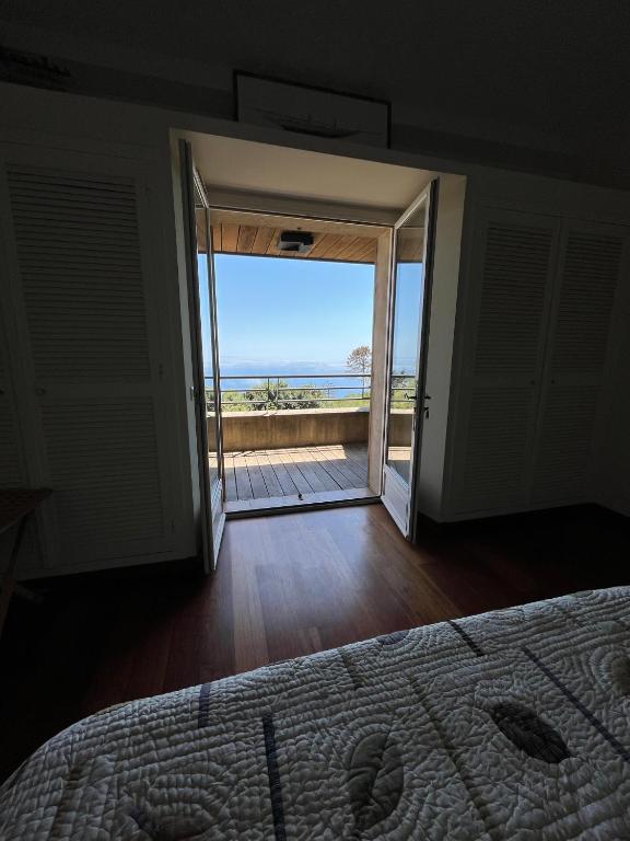 une chambre avec un lit et une vue sur l'océan dans l'établissement Maison En Pierre Corse Vue Mer, à Sari-Solenzara