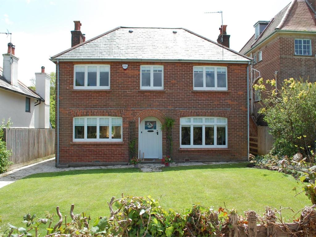 a red brick house with a yard at 3 Bed in Studland DC071 in Studland