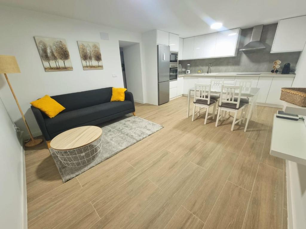 ein Wohnzimmer mit einem Sofa und einem Tisch sowie eine Küche in der Unterkunft Vivienda El Viajero in Valverde