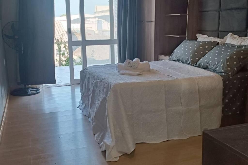a bedroom with a bed with two towels on it at Sobrado Completo Belíssima in Pelotas