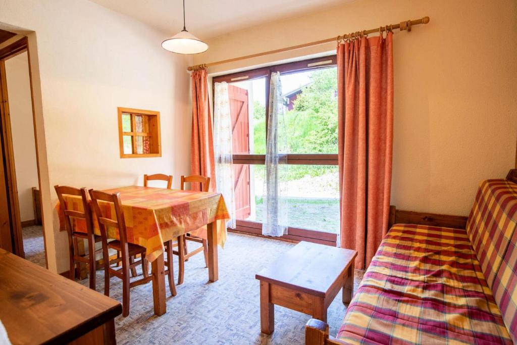 un salon avec une table et une fenêtre dans l'établissement Résidence Les Arolles - LES AROLLES - AR09B MAE-3056, à Villarodin-Bourget