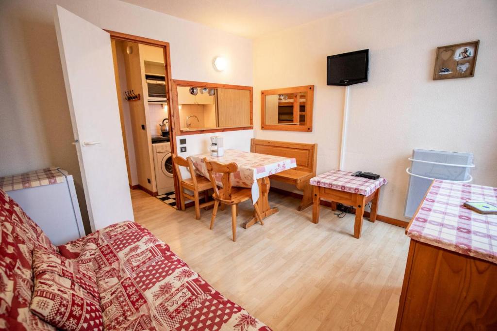 a living room with a table and a kitchen at Résidence Les Melezets 1 - Studio pour 5 Personnes 193079 in Modane