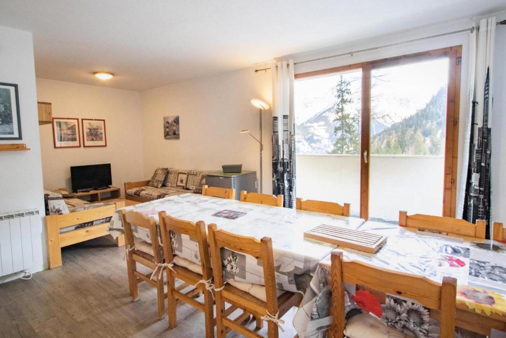une salle à manger avec une table et une grande fenêtre dans l'établissement Résidence Grand Argentier - GRAND ARGENTIER - GA08 MAE-3097, à Modane