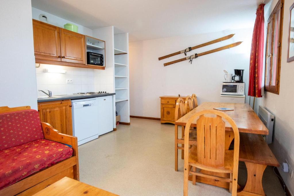 une cuisine et une salle à manger avec une table et des chaises dans l'établissement Chalet D'arrondaz H - CHALET ARRONDAZ - CHAARH21 MAE-3103, à Modane