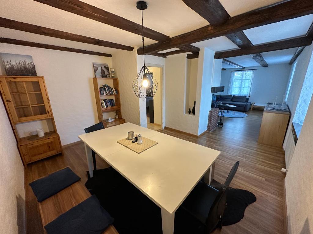 a living room with a white table and chairs at charmante 3,5 Zimmer Wohnung in Bauernhaus in Volketswil