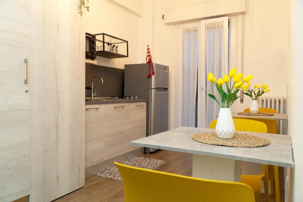 uma cozinha e sala de jantar com mesa e cadeiras amarelas em A casa di Serena em Ancona