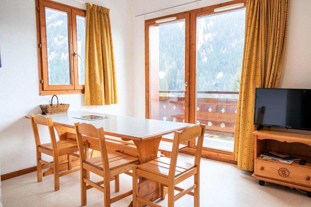 une salle à manger avec une table, des chaises et une télévision dans l'établissement Chalet Arrondaz J - CHALET ARRONDAZ J - CHAARJ24 MAE-3111, à Modane