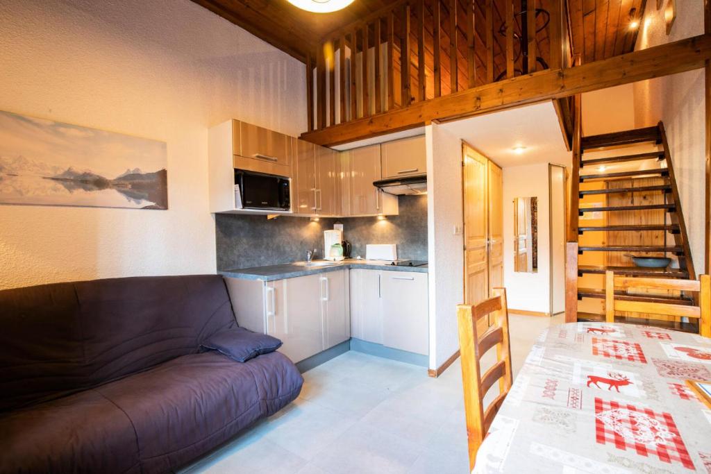 a living room with a couch and a kitchen at Résidence Le Grand Vallon - LE GRAND VALLON - NO52GV MAE-3116 in Villarodin-Bourget
