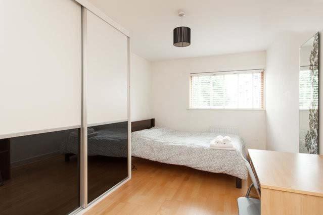 a small bedroom with a bed and a mirror at Double Bedroom with ensuite Regents Canal in London