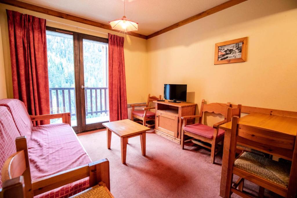 - un salon avec un lit et un bureau avec une télévision dans l'établissement Chalets Du Thabor - CHALET DU THABOR - CTHAA231 MAE-3136, à Modane
