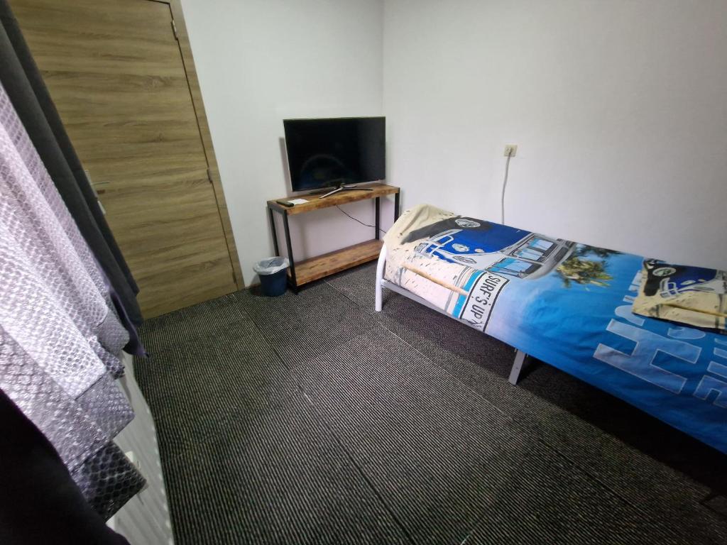 a bedroom with a bed and a door and a television at Central home in Brussels
