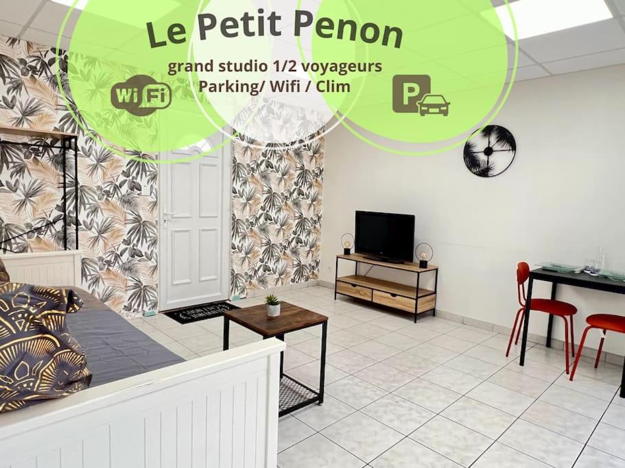 ein Wohnzimmer mit einem Sofa, einem Tisch und einem TV in der Unterkunft Le petit Penon ~ T1 Bis avec parking /clim /Fibre in Saint-Georges-lès-Baillargeaux