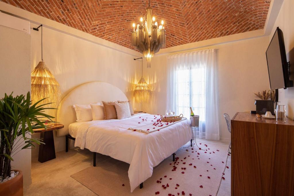 a bedroom with a white bed with roses on the floor at HOLT Hotel del Pueblito in San Miguel de Allende