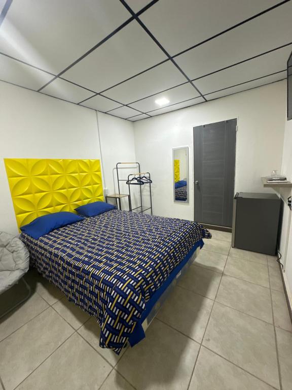 ein Schlafzimmer mit einem Bett mit gelbem Kopfteil in der Unterkunft Casa Mia in San Miguel