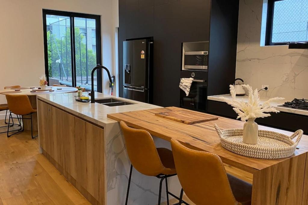 a kitchen with a island with a wooden counter top at Entire House in Port Melbourne w Parking & Pool in Melbourne