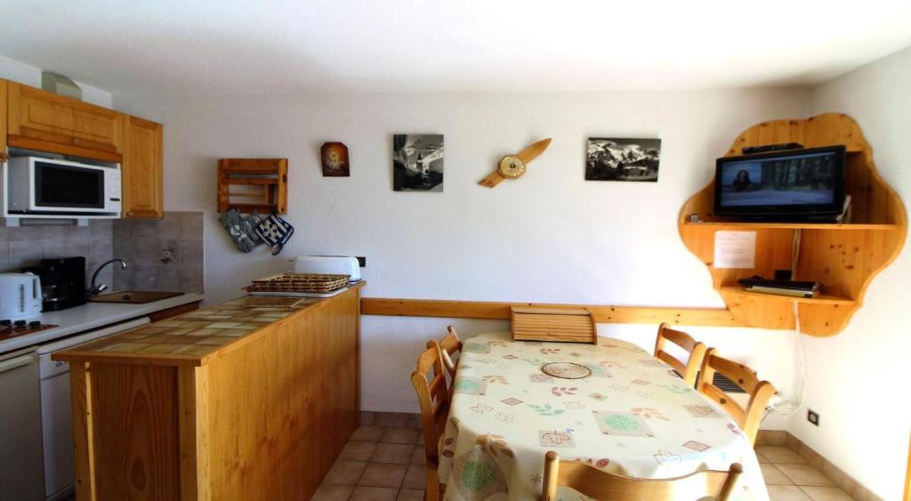 une cuisine avec une table et une petite cuisine avec une table et des chaises dans l'établissement Résidence Le Chardonnet - Appartement à 200 m des psites avec belle vue MAE-3282, à Champagny-en-Vanoise