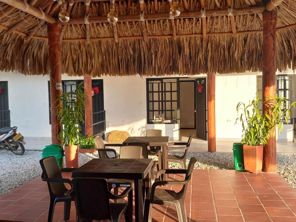 特里溫福港的住宿－finca campestre las heliconias，一间带桌椅和茅草屋顶的餐厅