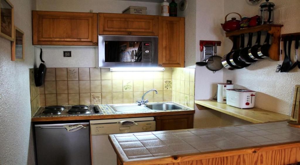 eine kleine Küche mit einer Spüle und einer Mikrowelle in der Unterkunft Résidence Le Centre - 2 Pièces pour 6 Personnes 193303 in Champagny-en-Vanoise