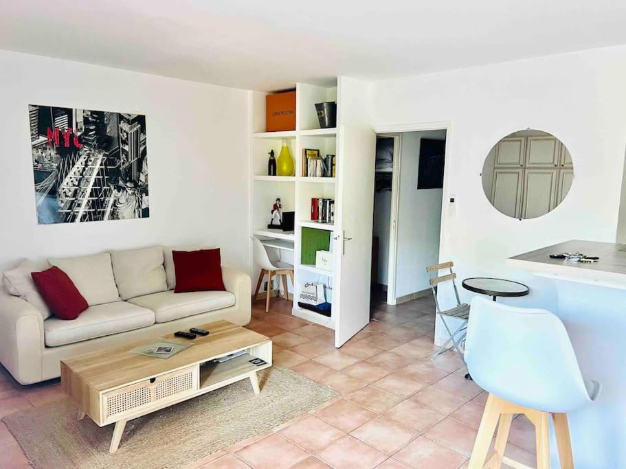a living room with a couch and a table at Chic Studio Climatisé avec Parking 5mn plage in Saint-Tropez
