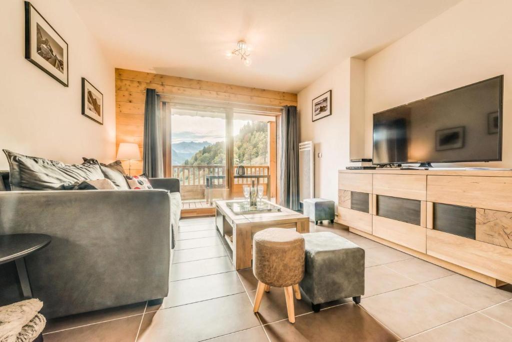 un salon avec un canapé et une télévision dans l'établissement Résidence Les Balcons EtoilÉs - Appartement 4 au pied des pistes MAE-3304, à Champagny-en-Vanoise