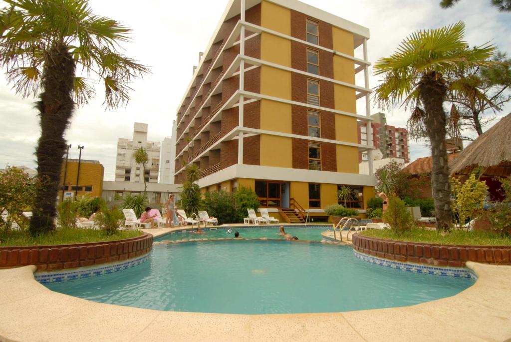 a swimming pool in front of a tall building at Hotel Chiavari in San Bernardo