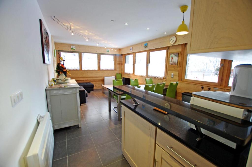 une cuisine avec des chaises et des tables vertes dans une pièce dans l'établissement Résidence Le Seillon - 3 Pièces pour 6 Personnes MAE-3325, à Champagny-en-Vanoise
