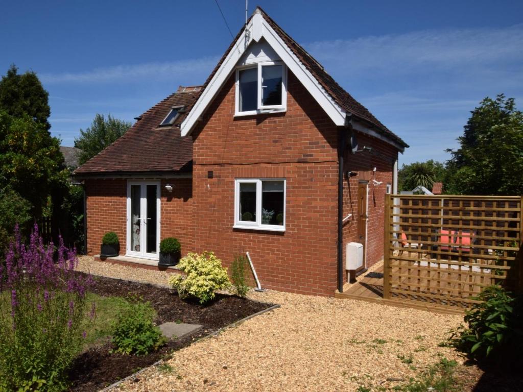 uma pequena casa de tijolos vermelhos com cerca em 2 Bed in Lyndhurst 75879 em Totton