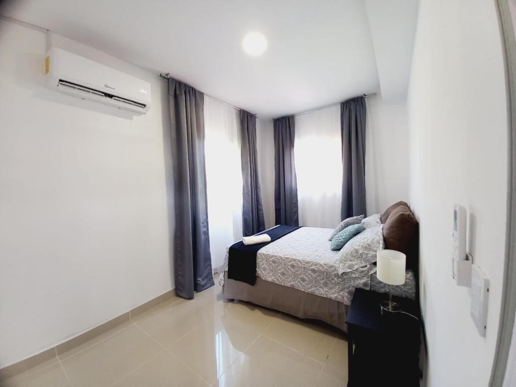 1 dormitorio con 1 cama y algunas ventanas en Villa San Diego, en San Pedro Sula