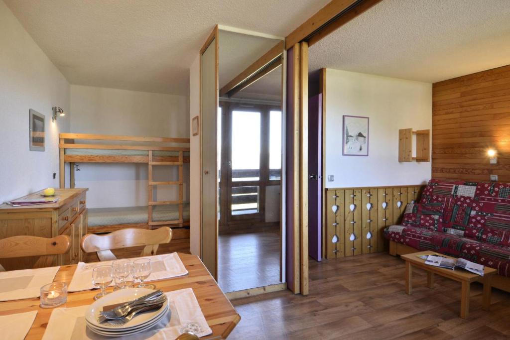 拉普拉尼馬孔的住宿－Résidence Beryl - Studio pour 4 Personnes 10，客房设有餐桌和双层床。