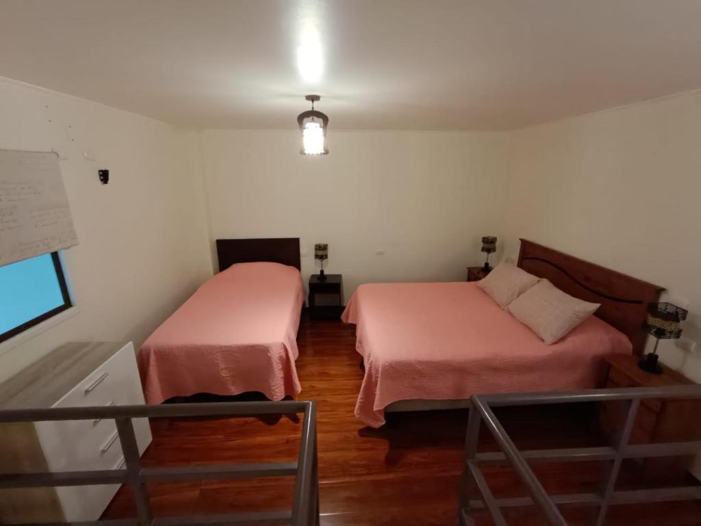a room with two beds in a room at Cafetto Hostal in Caldera