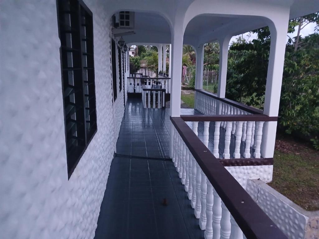 ganek białego domu z drewnianą poręczą w obiekcie Olosara Haven w mieście Sigatoka