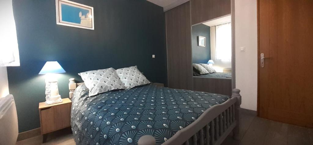 una camera con un letto con una parete blu di Maison pour 2 à 4 personnes avec jardin proche de la plage et des commerces ROYAN a Royan