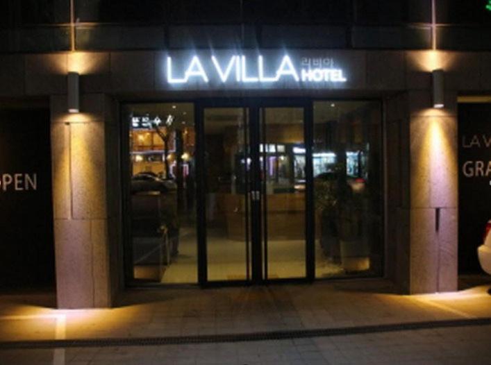 a store front with its doors lit up at night at La Villa Hotel in Seoul