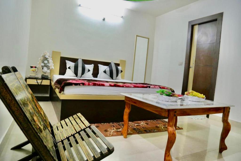 una camera con letto, tavolo e sedia di Hotel Blossom Family Rooms a Nagla Dhīmar