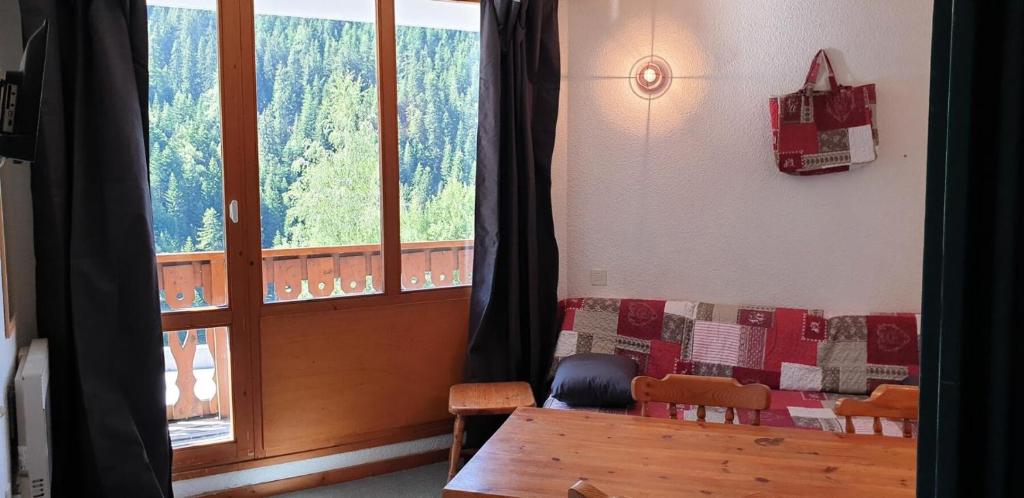 een kamer met een tafel en stoelen en een raam bij Résidence Thabor D - 2 Pièces pour 6 Personnes 28 in Modane