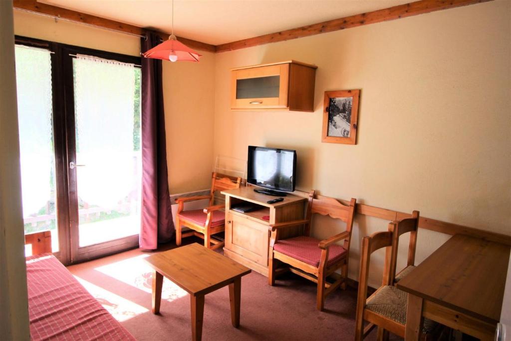ein Wohnzimmer mit einem TV und einem Schreibtisch mit einem Computer in der Unterkunft Chalets Du Thabor - 2 Pièces pour 4 Personnes 82 in Modane