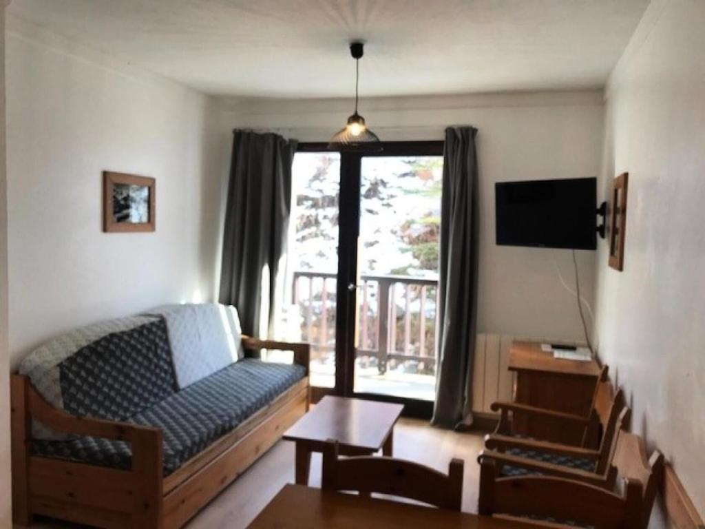 a living room with a couch and a window at Chalets Du Thabor - 2 Pièces pour 4 Personnes 83 in Modane