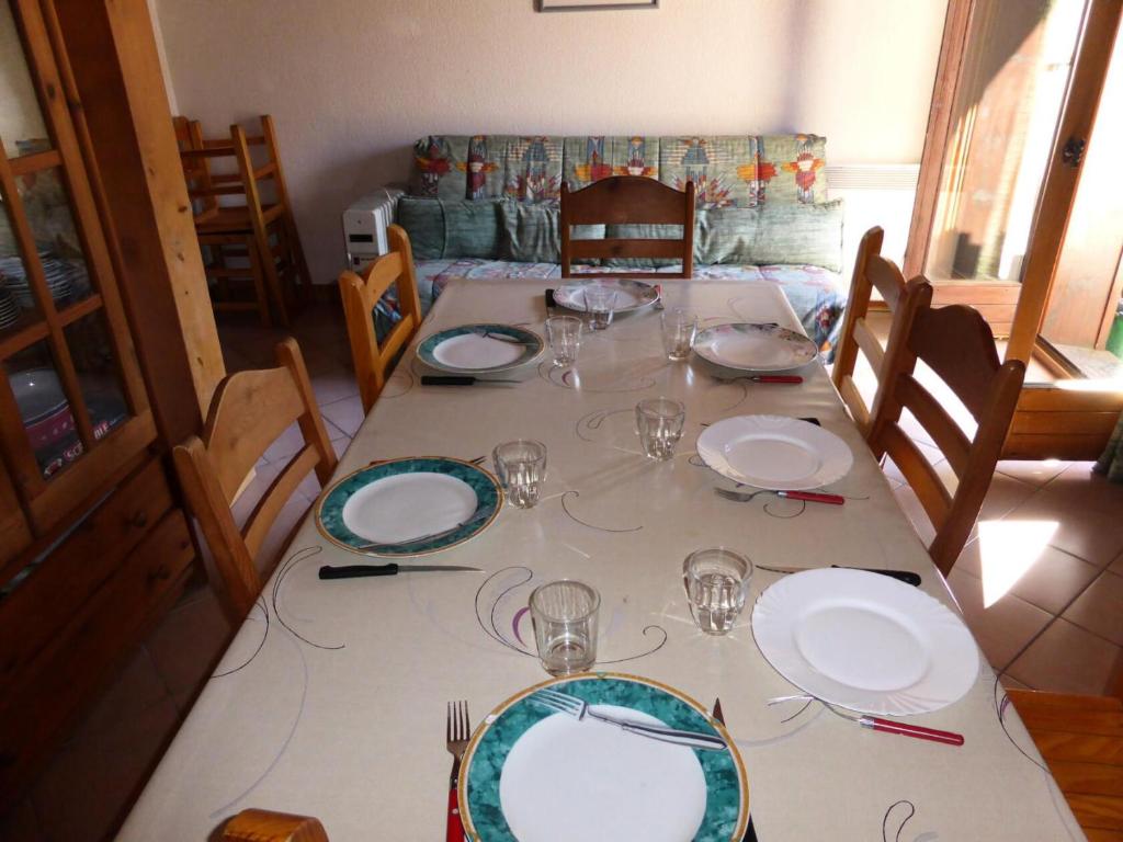 een tafel met borden en wijnglazen erop bij Résidence Les Jardins Alpins - 3 Pièces pour 8 Personnes 09 in Saint-Gervais-les-Bains