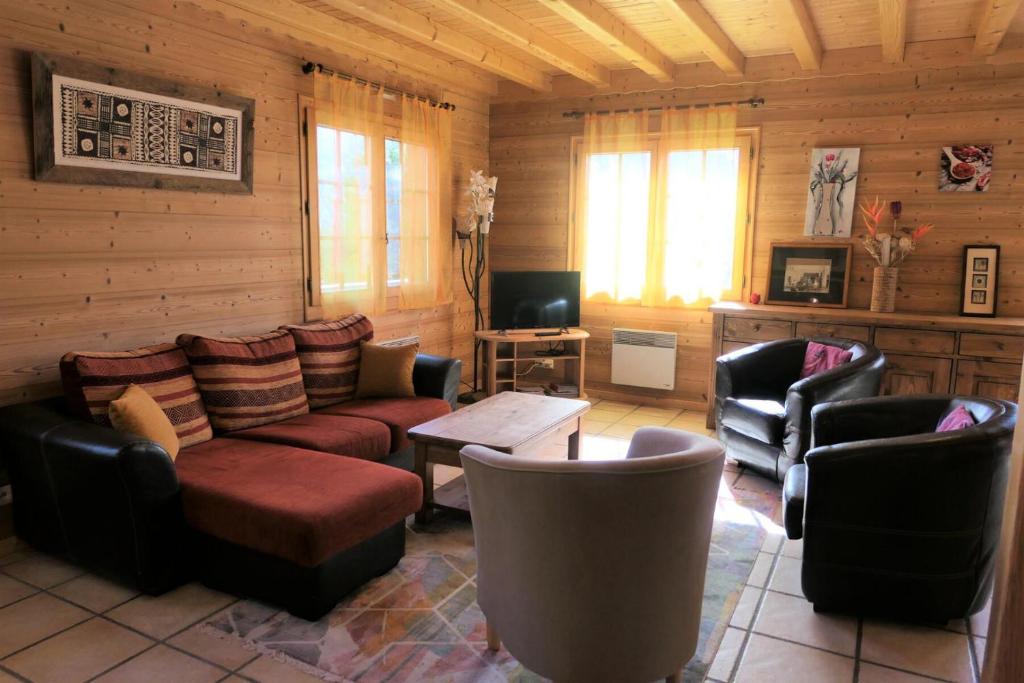 a living room with furniture in a log cabin at Chalet Granier - Chalets pour 6 Personnes 34 in Saint-Gervais-les-Bains