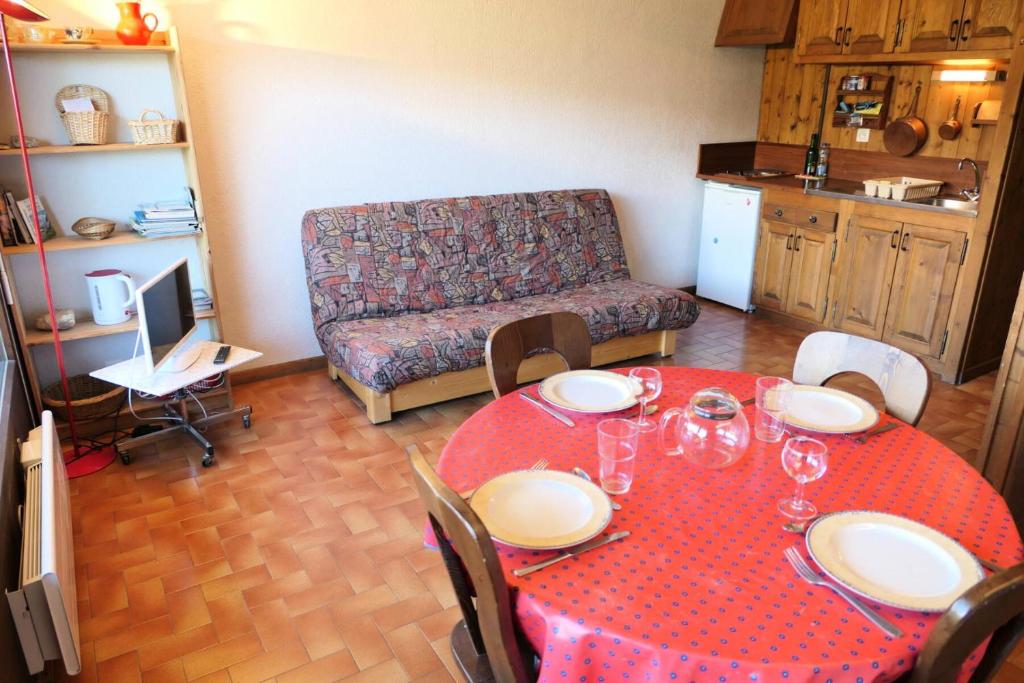 uma sala de estar com uma mesa vermelha e um sofá em Résidence La Gelinotte - Studio pour 4 Personnes 92 em Saint-Gervais-les-Bains