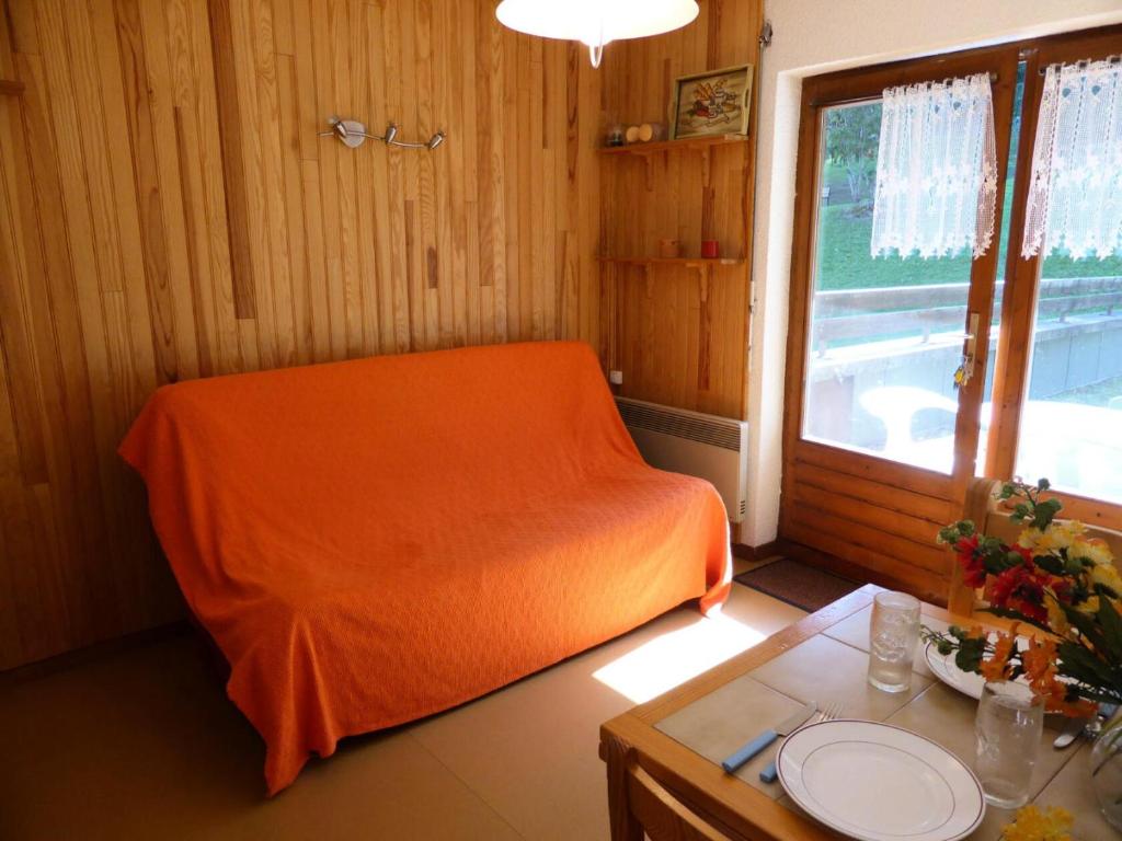 - un lit orange dans une chambre avec une table dans l'établissement Résidence Ecrin Des Glaciers Daim - Ecrin des Glaciers D31 MAE-5313, à Combloux