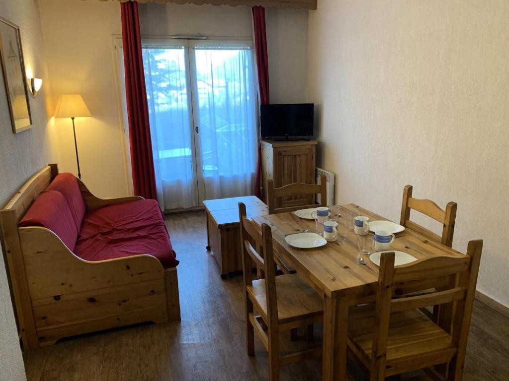 un salon avec une table, des chaises et une télévision dans l'établissement Résidence Le Grand Panorama - Grand Panorama 001 MAE-5280, à Saint-Gervais-les-Bains